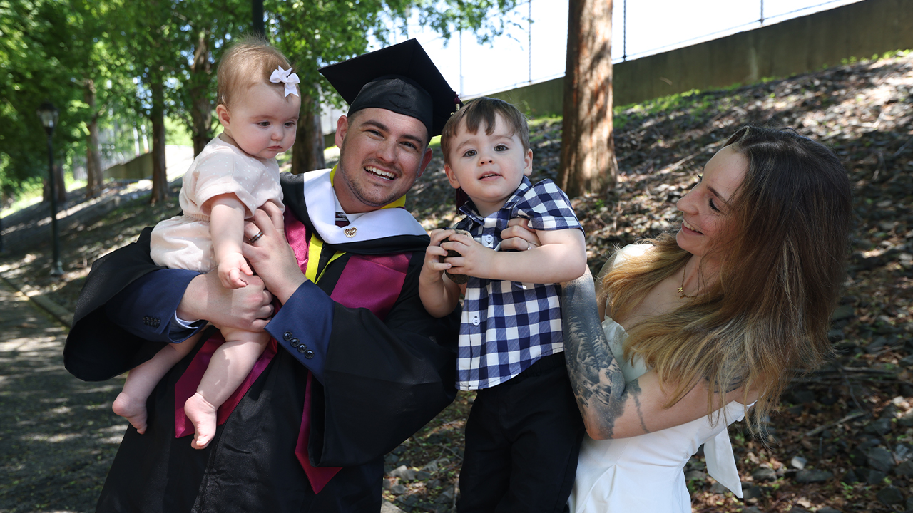 PCS and veteran grad Andew Hervieux with his wife and two children outdoors
