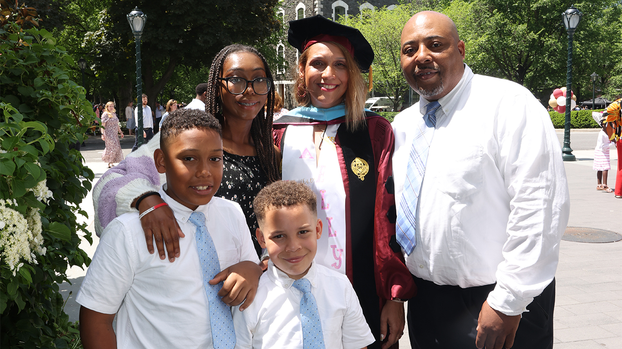 Elizabeth Blanco-Rowe posing with her husband and three children at Commencement