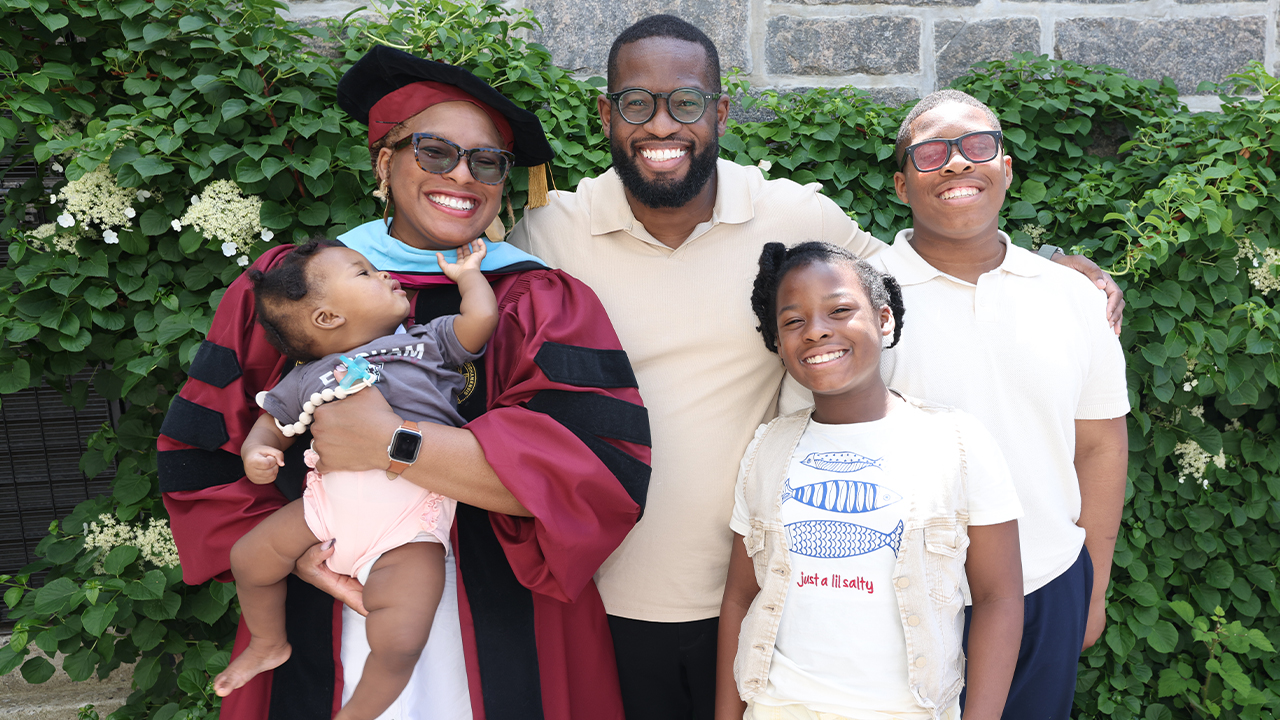 Malynda Colvert posing with her husband and three children in front of vines