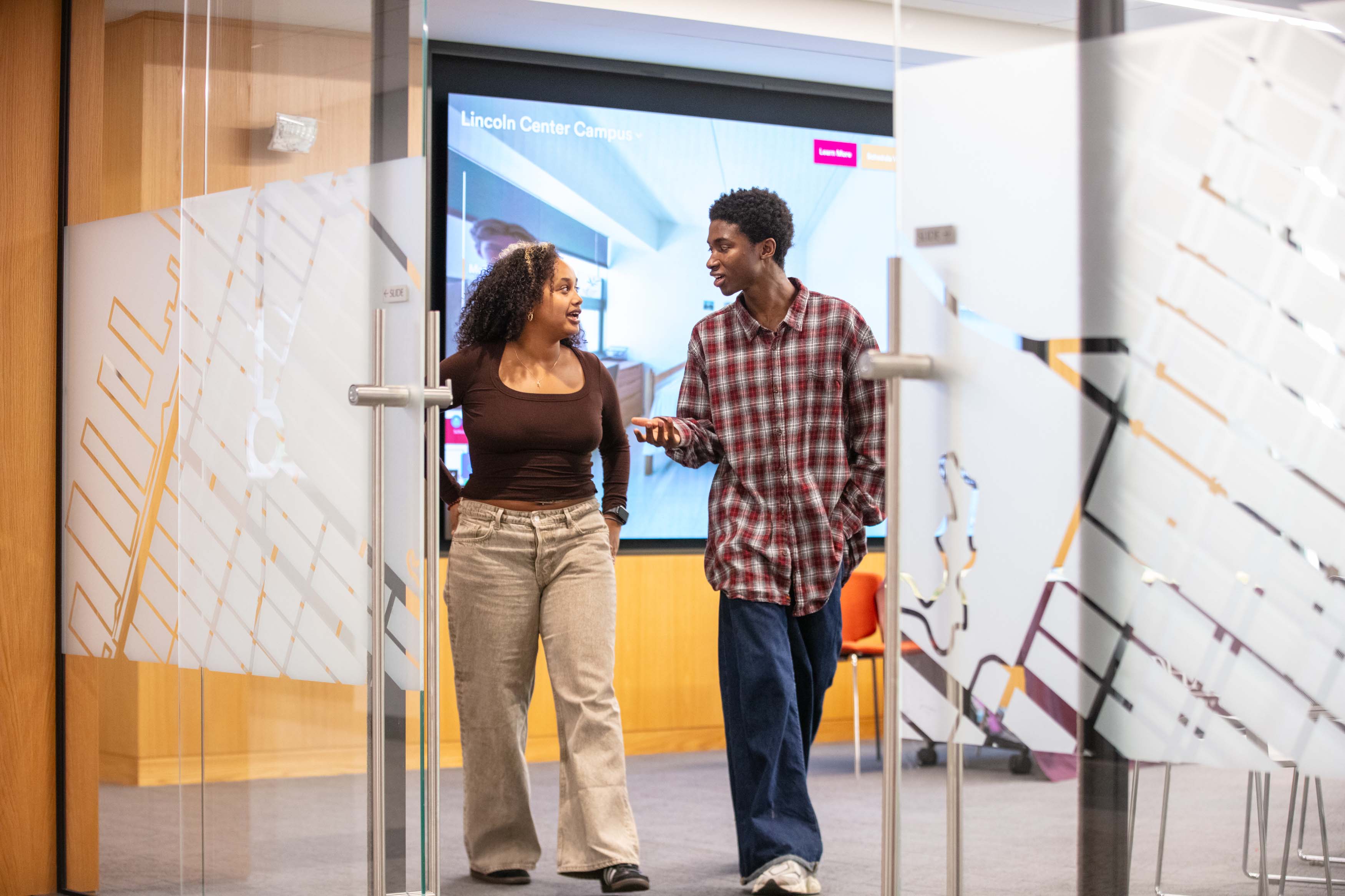 two students walking out of a classroom