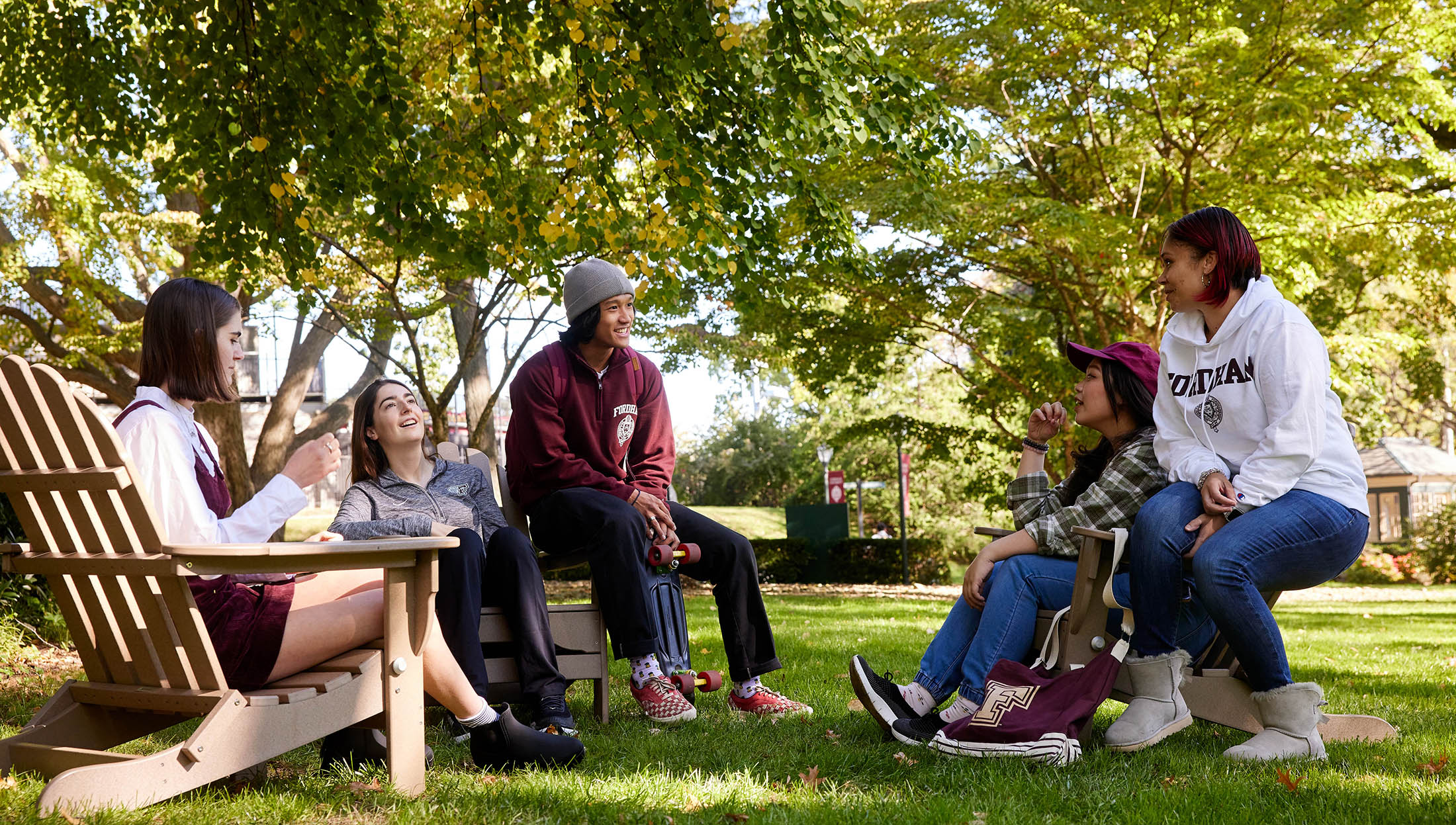 Students sitting on Adirondack chairs at the Rose Hill campus