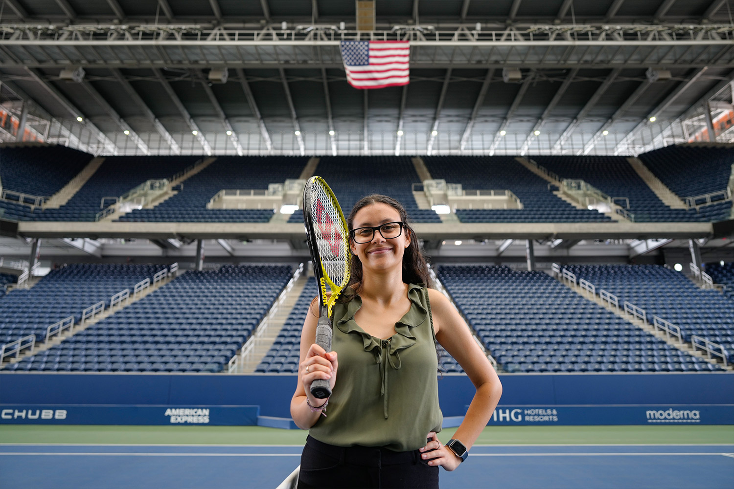 Bianca stands on center court at U.S. Tennis Center with racquet in hand.