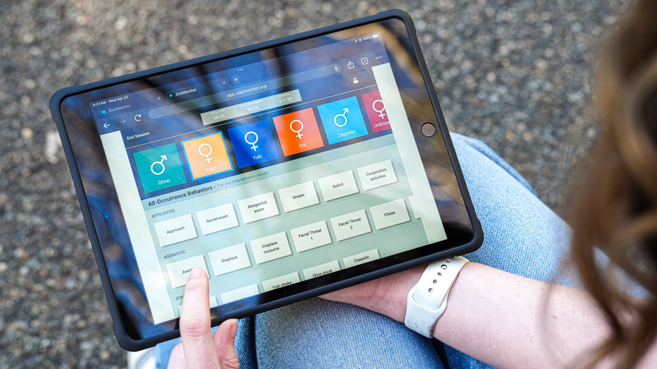 Shannon holds an iPad with data about monkeys.