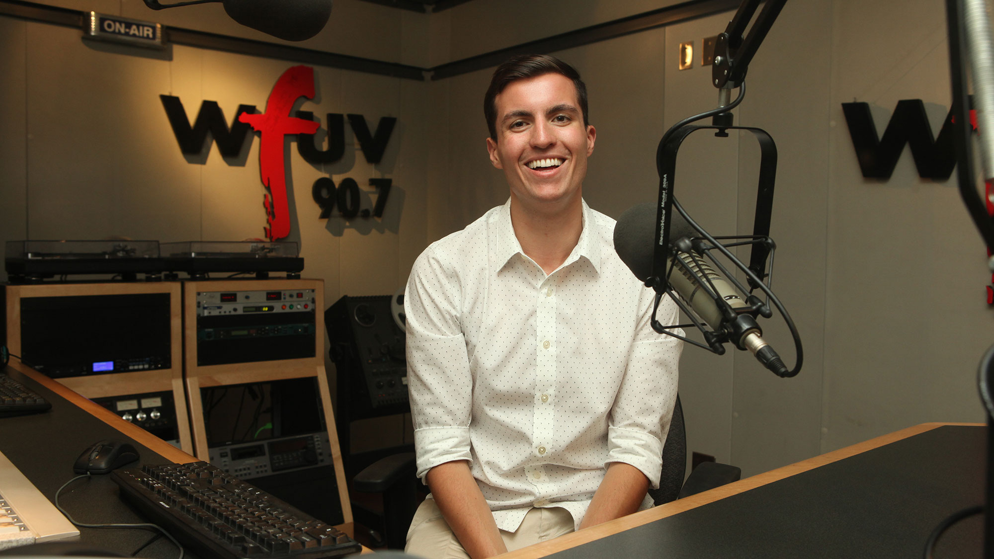 A man sits in front of a microphone