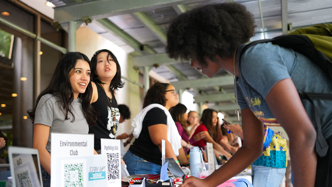 A student signs up for the environmental club at the club fair.