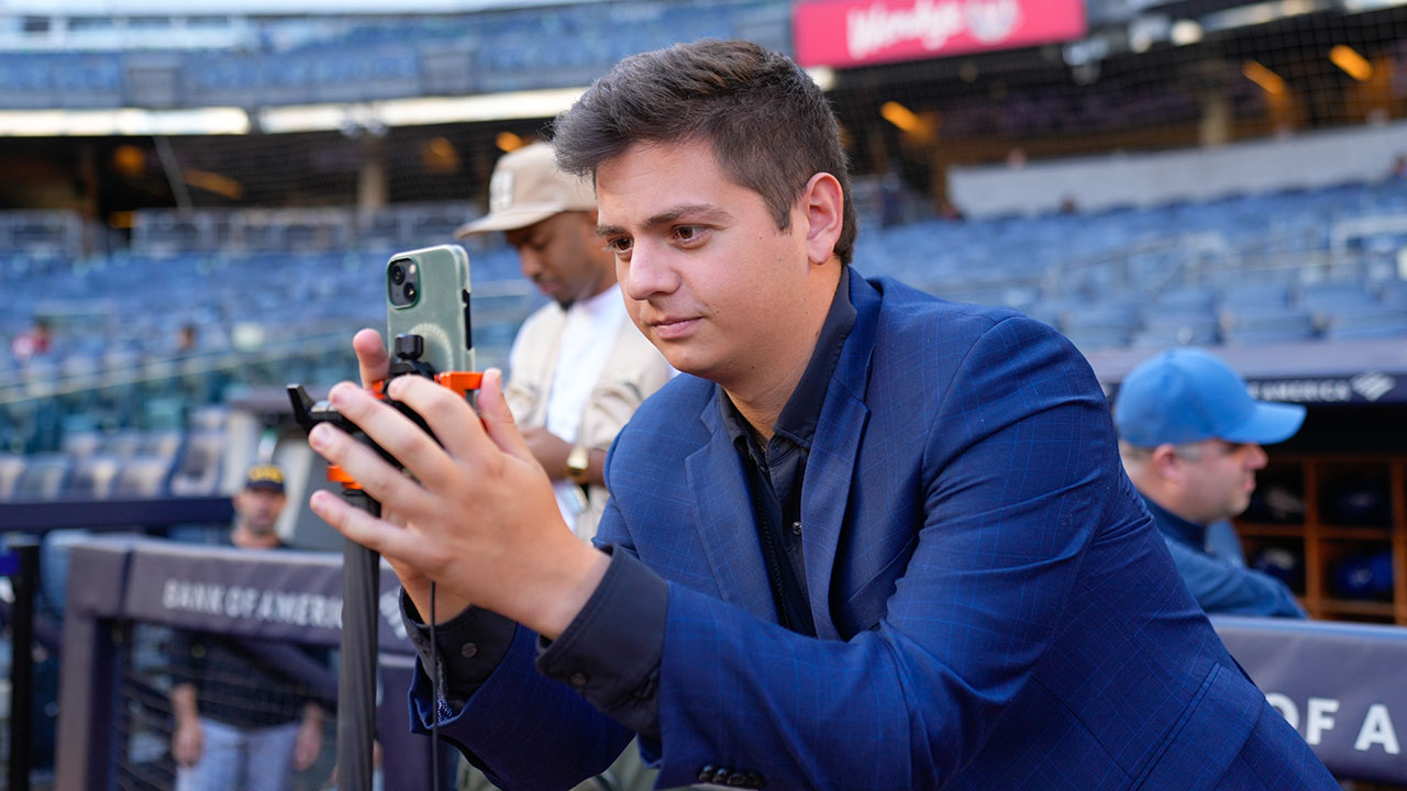 A student takes video on the field at Yankee Stadium