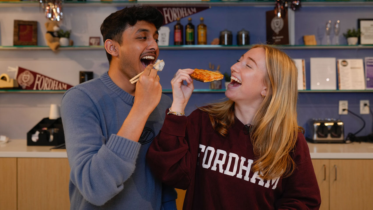 One student eating sushi with another eating pizza at the Rose Hill marketplace