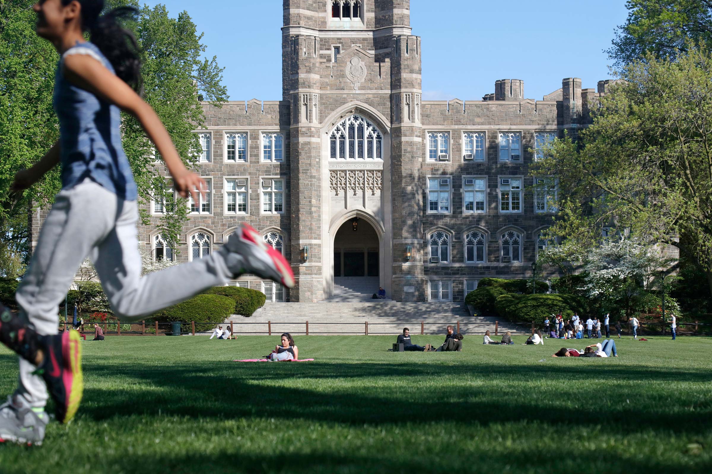 Students relax and unwind on the grass in front of Keating Hall on the Rose Hill campus