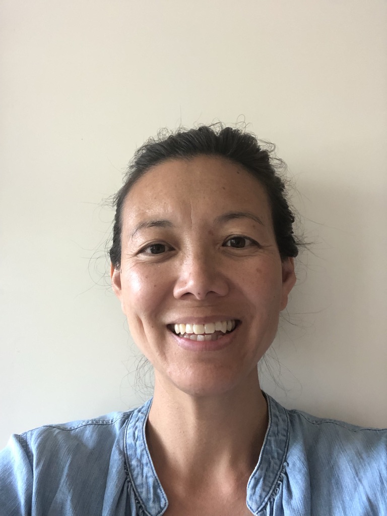 A headshot photo of Lynn Tang Lee, a a doctoral student in the systematics track in the Theology Department at Fordham University. Lynn has black hair tied behind her head.