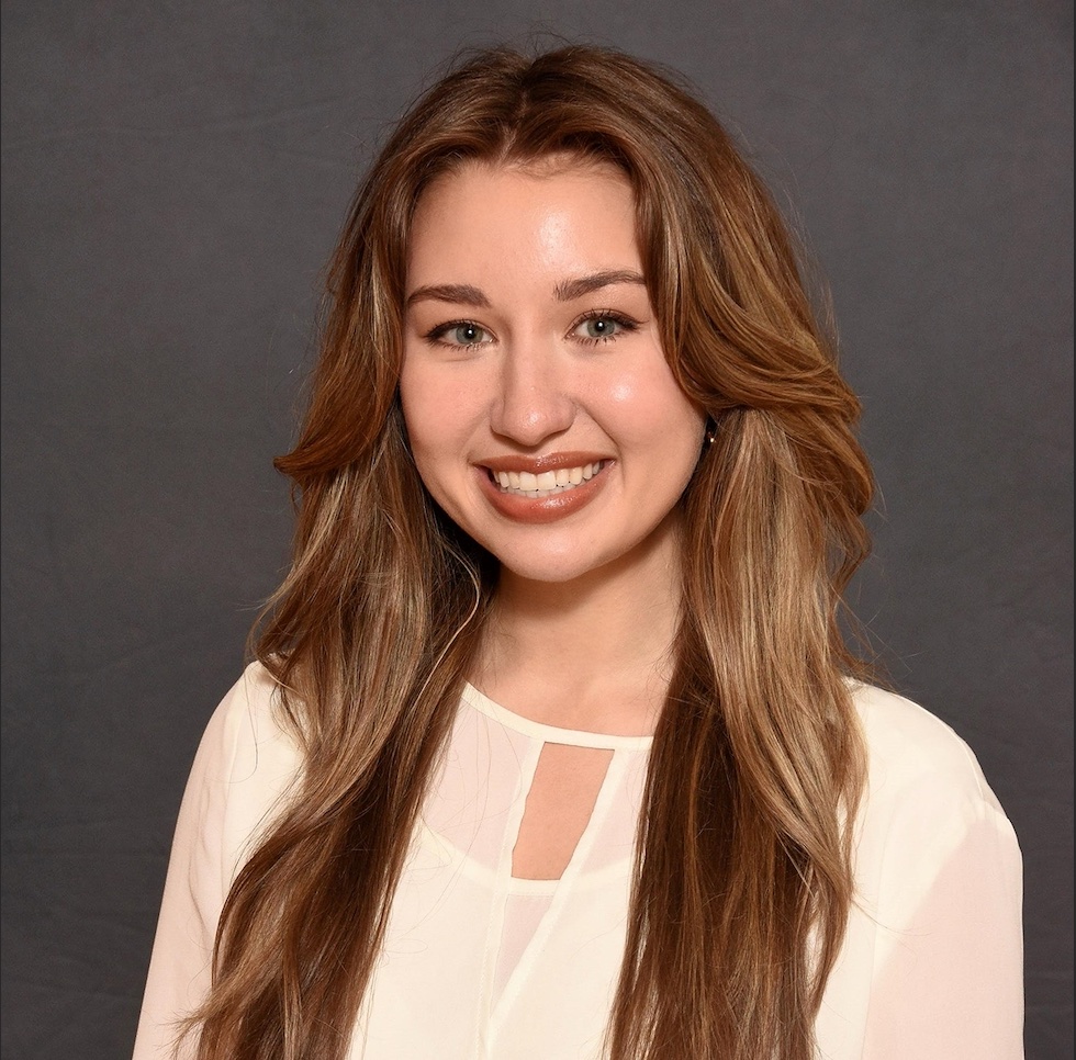 A headshot photo of Makayla Bezzant, a a doctoral student in the Judaism and Christianity in Antiquity track in the Theology Department at Fordham University. Makayla is wearing a white shirt.