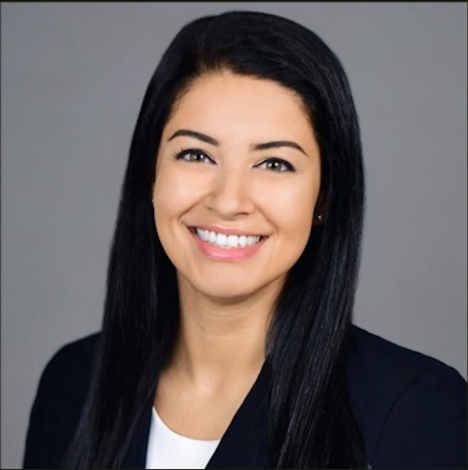 Young woman in a dark jacket with dark hair.