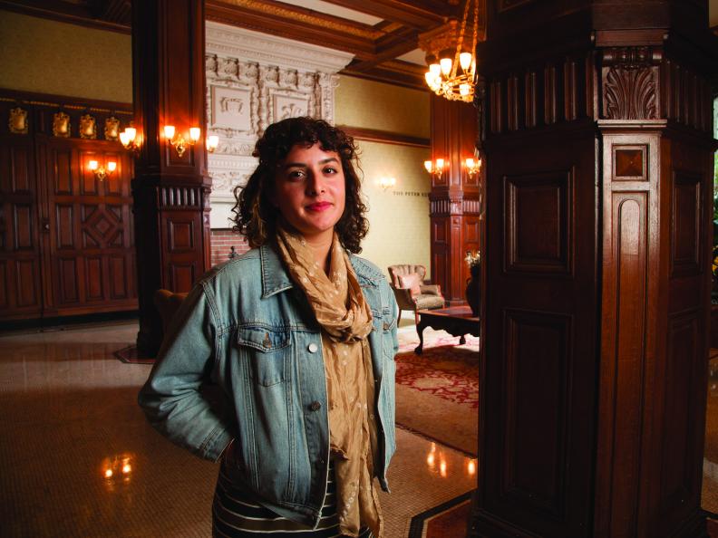 Young woman with curly hair in a denim jacket.