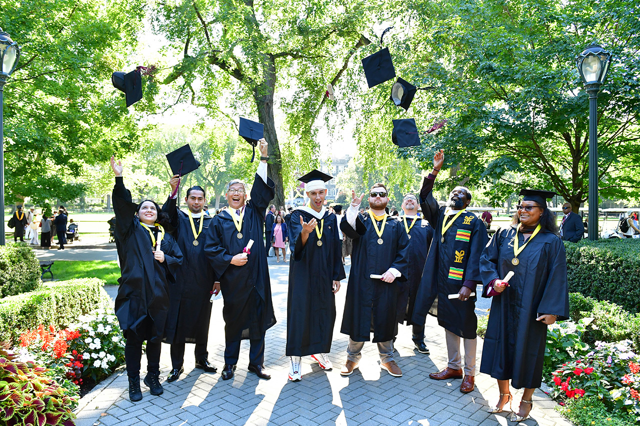 A group of veterans tossing their caps at Commencement