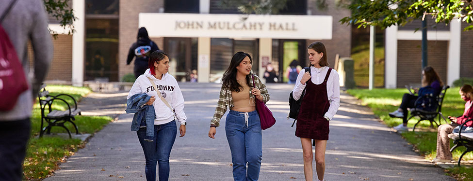 Students walking on Rose Hill Campus with JMH building in the background