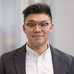 Qiangwen Xu Standing in Front of a White Background