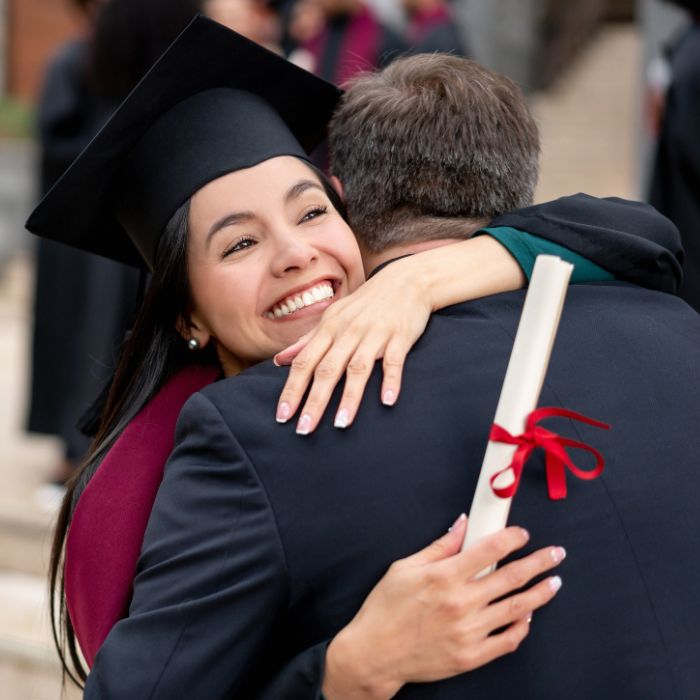 Law School Graduate hugs father holding diploma