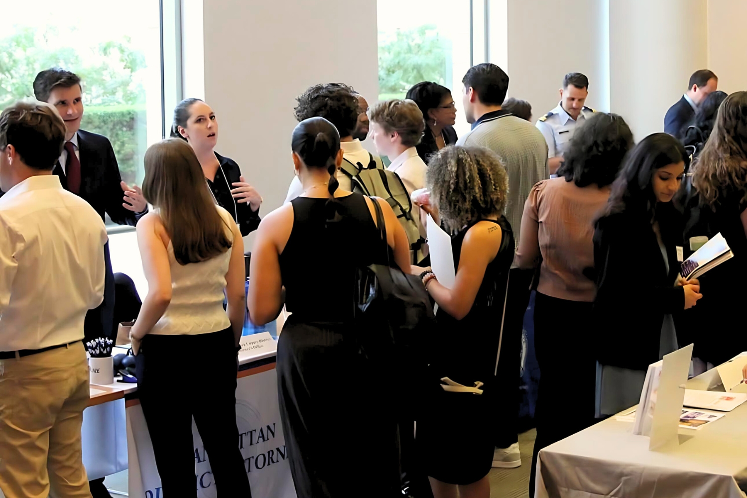 Professionals networking at a reception by window