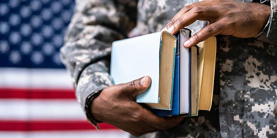 US vetran holding books with flag in the background